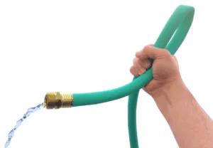 A hand kinking a garden hose, cutting off the water flowing through it